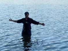 a man standing in the water with his arms outstretched