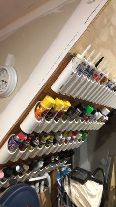 there is a rack full of paint and other items on the wall in this room