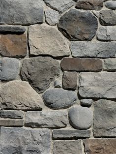 a stone wall that is made out of various types of rocks and has been used as a background