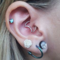 a close up of a person with some piercings on their ears and behind the ear