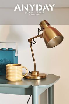 an image of a desk with a lamp on it and a cup next to it