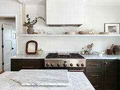 a kitchen with marble counter tops and open shelves