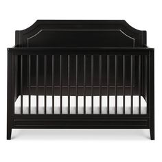 a black crib with white sheets on the bottom and side rails, in front of a