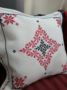 a white pillow with red and black designs on it