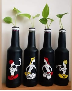 three black bottles with plants growing in them