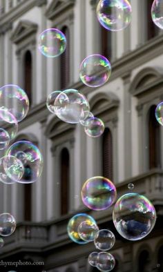 soap bubbles floating in front of a building