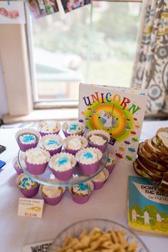 a table topped with cupcakes and cookies