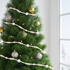 a decorated christmas tree in front of a window