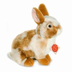 a brown and white stuffed rabbit with a tag on it's ear, sitting in front of a white background