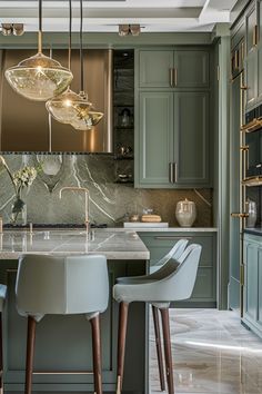 a kitchen with green cabinets and marble counter tops, two chairs at the center island