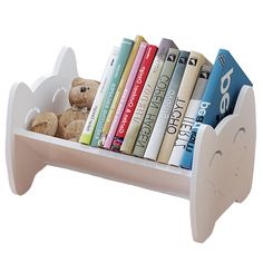 a white book shelf with books and stuffed animals on the top, in front of a white background