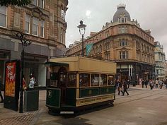 a trolley car is parked on the side of the road in front of some buildings