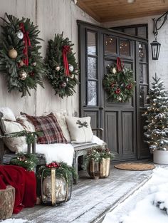 a porch decorated for christmas with wreaths and decorations