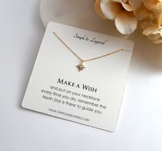 a necklace that says make a wish and has a star on it next to a flower