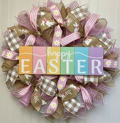 a wreath with the word happy easter painted on it and ribbons attached to each letter