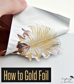 a hand holding a piece of white paper with gold foil on it and the words how to gold foil