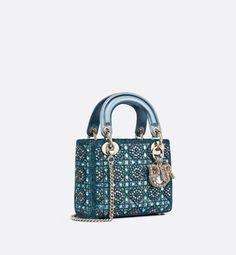 The Lady Dior bag epitomizes Dior's vision of elegance and beauty. It demonstrates the House's unique leather craftsmanship and is offered in celestial blue satin, embroidered with a multitude of beads in a hallmark Cannage-motif design, while the handles are made with tonal metallic lambskin. Pale gold-finish metal D.I.O.R. charms are adorned with white crystals and further embellish its silhouette. The miniature style, with its removable chain shoulder strap, can be carried by hand or worn cro Lady Dior Mini, Tas Lv, Mini Lady Dior, Christian Dior Bag, Celestial Blue, Pearl Embroidery, Womens Designer Bags, Small Lady, Christian Dior Couture