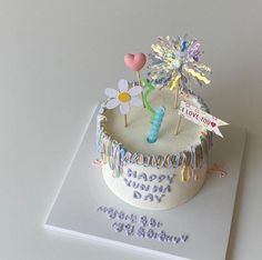 a birthday cake is decorated with flowers and candles for someone's special day,