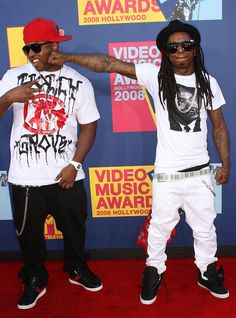 two young men standing next to each other on a red carpet