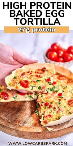 a person holding a piece of pizza on top of a wooden cutting board with tomatoes in the background