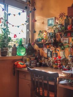 a kitchen counter topped with lots of pots and pans filled with plants next to a window