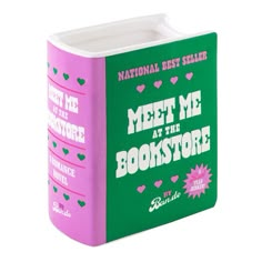 a pink and green book with the words meet me at the bookstore written on it