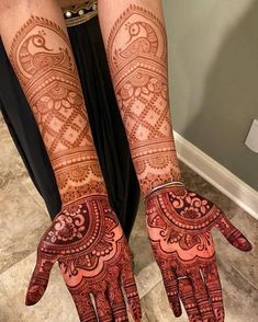 two hands with henna tattoos on them