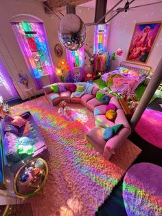 a living room filled with lots of furniture and colorful lights on the walls above it