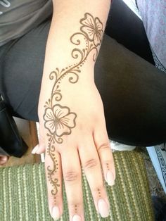 a woman's hand with henna tattoos on it