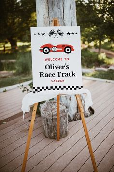 a sign that is on top of a wooden easel in front of a tree