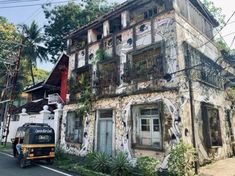 an old building with vines growing on the windows and balconies is being worked on