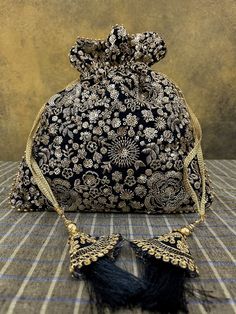 "Black silk Indian potli bag with heavy gold hand embroidery sequence work and black tassels. Wedding favor drawstring gifting bag or purse. Material: Silk with heavy gold embroidery Size: 10\" (h) x 9.5 \" (w) This beautifully embroidered potli bag will enhance any of your outfits! The design is delicately hand   embroidered in  pale gold metallic flowers on black silk. And it's perfect for Indian weddings, as return gifts or as a gift bag!" Festive Evening Bags With Tassels, Festive Gold Bag With Tassels, Festive Celebration Bags With Tassels, Elegant Festive Bags With Tassels, Elegant Festive Tassel Bags, Festival Potli Bag With Tassels For Party, Festive Party Bags With Tassels, Festive Elegant Potli Bag With Tassels, Gold Potli Bag With Tassels For Festivals