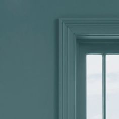 an open window in a white room with blue walls and green trim on the windowsill