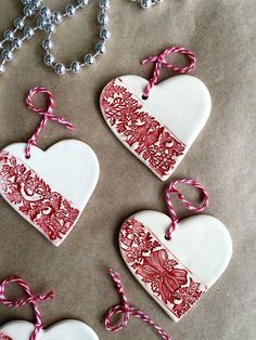 four heart shaped ornaments with red and white designs