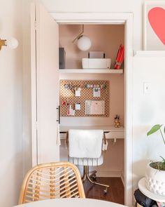 a white desk and chair in a room with a heart painted on the wall above it