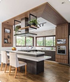 a modern kitchen with an island counter and chairs in the center, surrounded by wood paneling