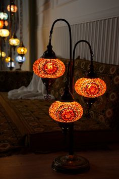 three lights that are sitting on top of a table in front of a couch and rug