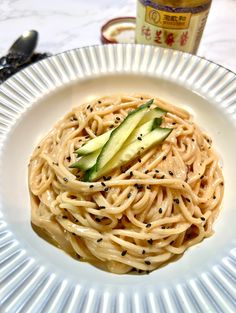 a white plate topped with noodles and cucumbers