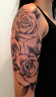 a woman's arm with three roses on it and one is black and white