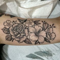 a black and white flower tattoo on the arm