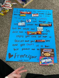 a blue sign sitting on top of a carpet next to a pile of candy bars