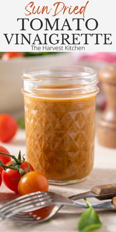 sun dried tomato vinaigrette in a jar next to tomatoes