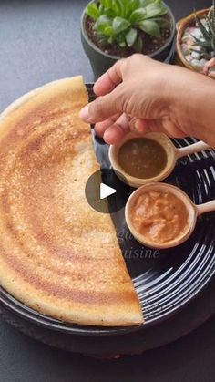 a pancake being served with dipping sauces