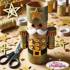 a nutcracker made out of toilet paper and gold glitters next to scissors