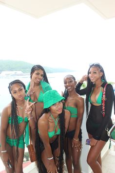 a group of young women standing next to each other in swimsuits and hats