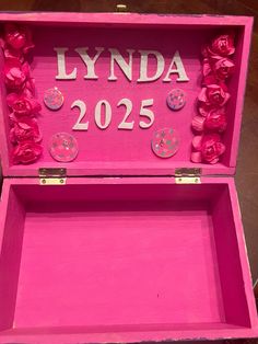 a pink box with buttons and flowers on the lid that says lynda 205