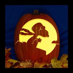 a carved pumpkin with an image of a dog in the center and leaves around it