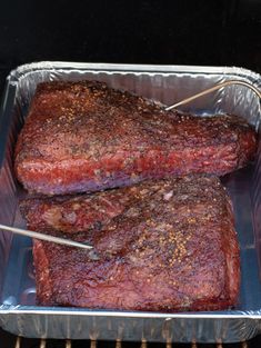 two steaks are being cooked on the grill