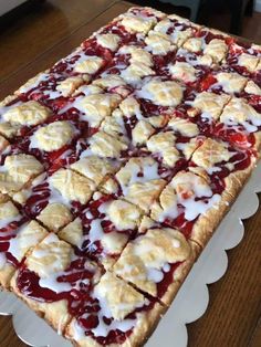 a cake that is sitting on top of a table with white icing and toppings