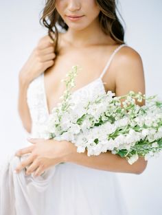 a woman in a white dress holding flowers